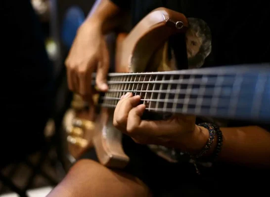 closeup of a musician playing a bass guitar