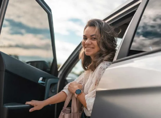 woman smiling as she exits her car